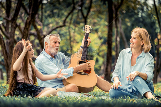 快乐的家庭弹吉他和在公园一起唱歌图片