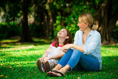 在公园草坪上愉快聊天的母女图片