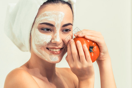 接受番茄面膜面部皮肤美容护理的美女背景图片