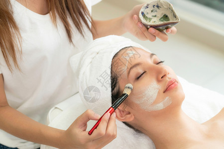 美女接受皮肤科医生的面部擦拭治疗服务图片