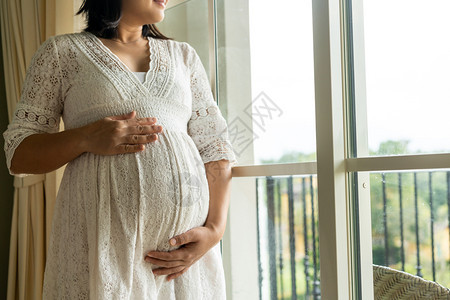 孕妇抚摸肚子的特写镜头图片