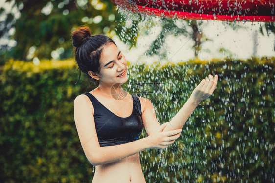 年轻妇女在泳池边洗澡图片