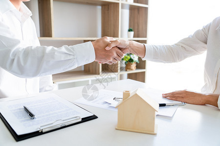 房屋开发商和客户在完成购买后握手图片