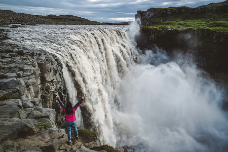 女游客被壮观的瀑布所震撼高清图片