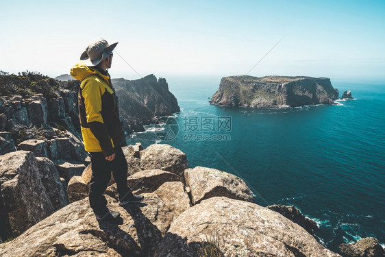 旅客在海边悬崖上观赏大海图片