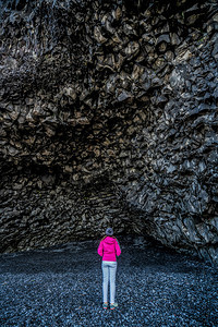 火山黑岩洞穴下的旅行者图片