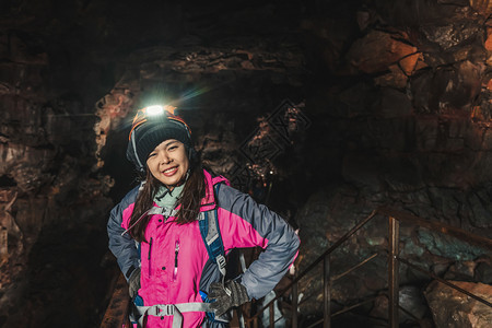 女旅行者探索冰原的熔岩隧道图片