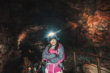 女旅行者探索冰原的熔岩隧道图片