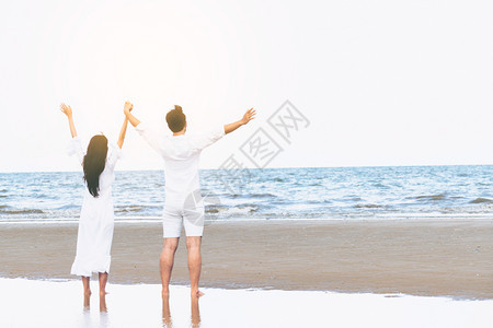 情侣在海滩上跳跃欢呼图片