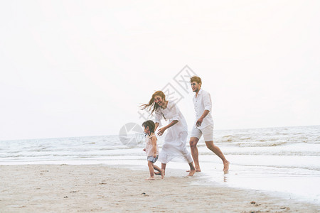 夏天热带沙滩度假的幸福一家人图片