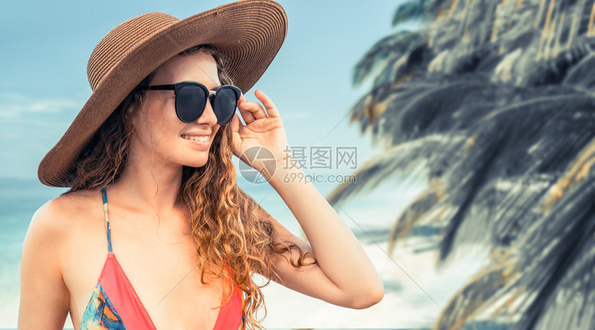 夏天在热带沙滩度假胜地穿泳衣的快乐年轻女子度假图片