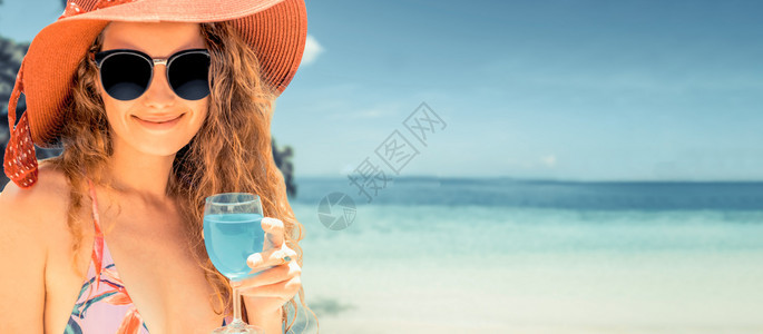 夏天在热带沙滩度假胜地穿泳衣的快乐年轻女子图片