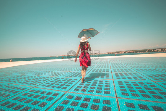 女旅行者在户外迪斯科地板上撑伞跳舞图片