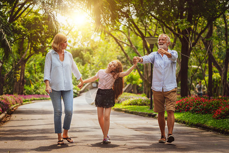 快乐的幸福家庭在一起走在公园的路上图片