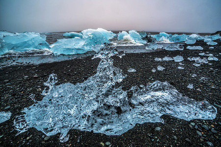 冰山在原上的钻石海滩黑沙冰冻的块被称为钻石海滩流图片