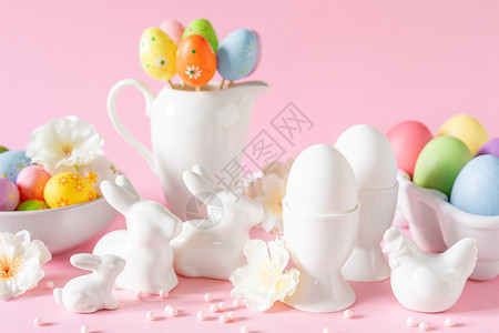 粉红色背景的鸡蛋和兔子装饰品图片
