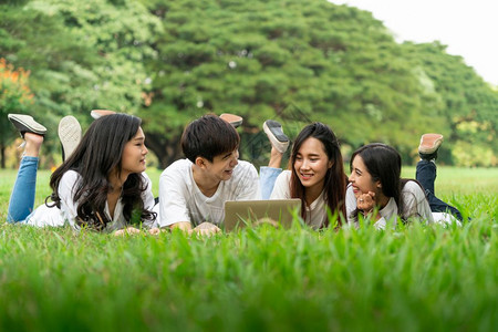 校园里趴在草地上学习的大学生们图片