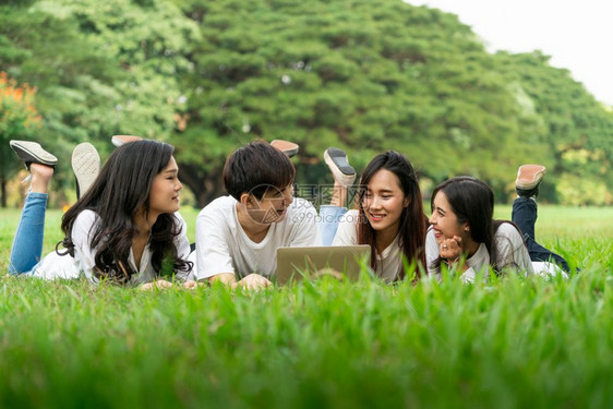 校园里趴在草地上学习的大学生们图片