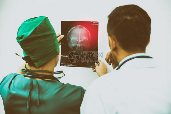 医生和外科检查病人和的x光薄膜脑头骨图片