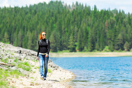 女游客在湖泊边放松心情图片