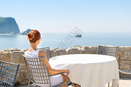 女性坐在蒙泰格罗豪华酒店前海边露台看风景图片