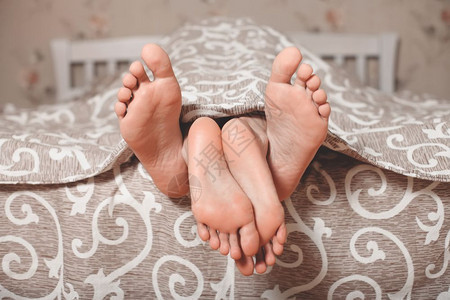 情侣的双脚从毯子伸出图片