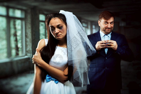 泪流满面的新娘背景上带着狡黠微笑的新郎不幸的婚姻泪流满面的新娘和狡黠微笑的新郎图片