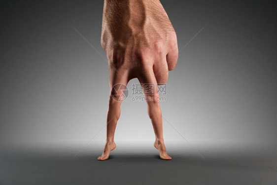 男手用腿而不是手指在灰色之上男手用腿图片