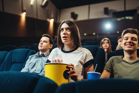 一个拿着爆米花的女人在电影院看电影表演时间电影在电影院看电影的惊讶女人图片