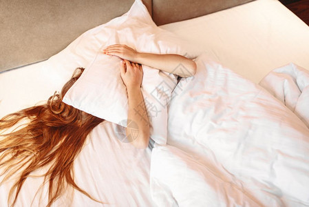 美丽的女人拥抱枕头醒来早上在家睡卧室放松美丽的女人拥抱枕头醒来图片