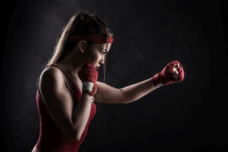 红色拳击绷带和运动服训练中的女拳击手图片