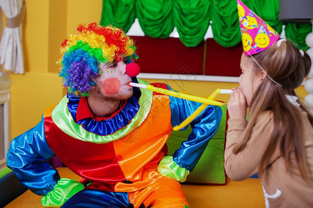 快乐的小丑和女孩在生日派对上玩图片