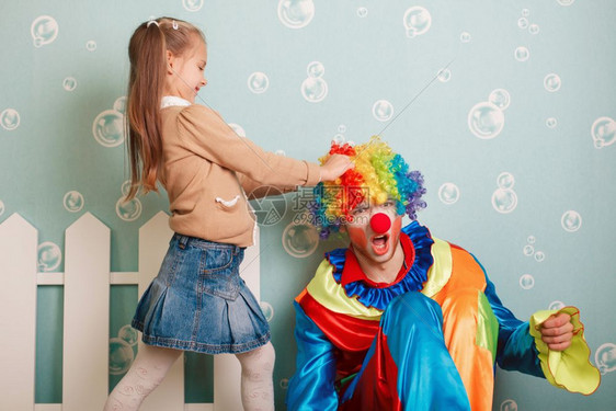 小女孩拉着小丑的头发图片
