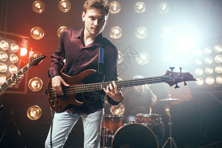 吉他手在bas摇滚乐队背景有灯光的舞台上演奏现场音乐会吉他手在bas摇滚乐队上演奏图片