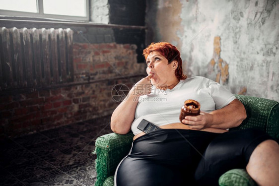 胖女人坐在椅子上吃甜食图片