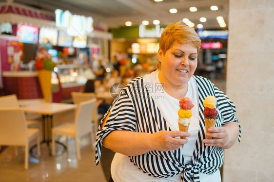 肥胖症超重的女人手拿冰激凌图片