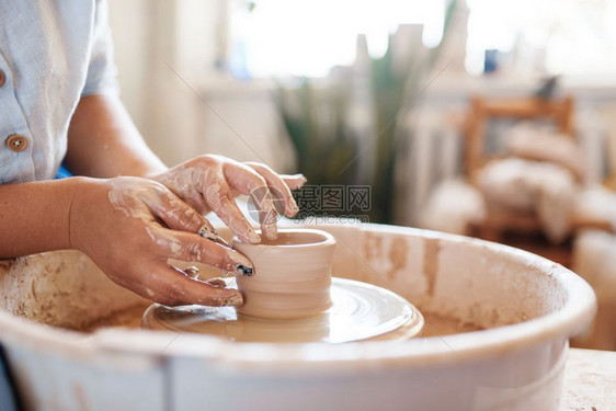 在陶轮上做壶的女陶工塑造碗的女人手工陶瓷艺术粘土餐具图片