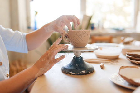 陶艺作坊女陶工用手指剥壶皮塑造碗的女人手工陶瓷艺术粘土餐具女陶工用手指剥罐子皮图片