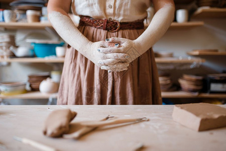 女工匠手上沾满干粘土以陶器作坊内部为背景塑造碗的女人手工陶瓷艺术餐具制作手上沾满干粘土陶器的工匠图片