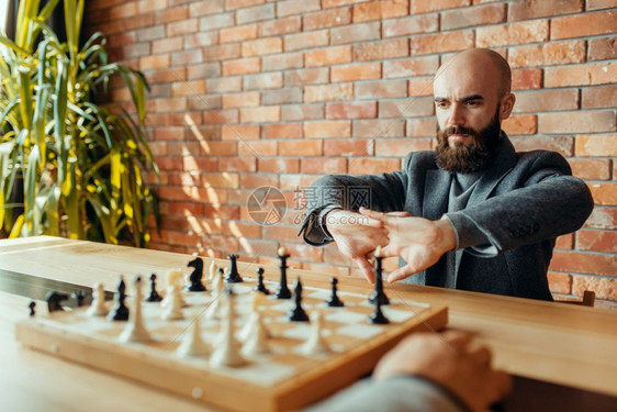在室内下棋的男子图片