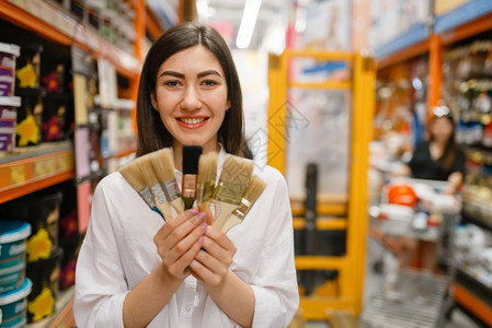 在五金店中选择刷子的女顾客图片