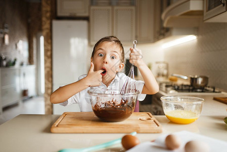 快乐的小孩在吃碗里的巧克力图片
