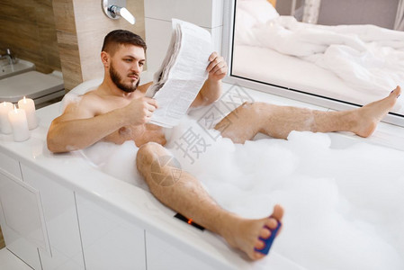 男人在洗澡时阅读报纸图片