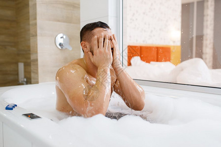 男人在浴室洗澡时用泡沫洗脸图片