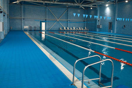 空泳池边有铁轨和梯子蓝水瓷砖是健康生活的公共场所图片