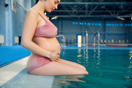在游泳池中游泳的孕妇图片