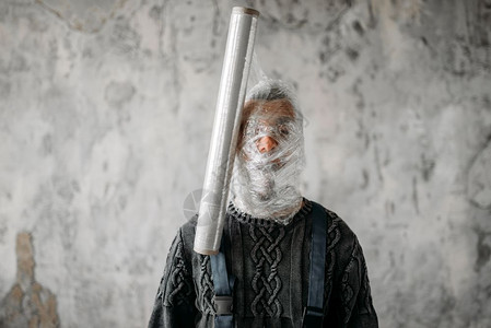 被闹钟吵醒烦躁的男子被保鲜膜缠住头部的男子背景