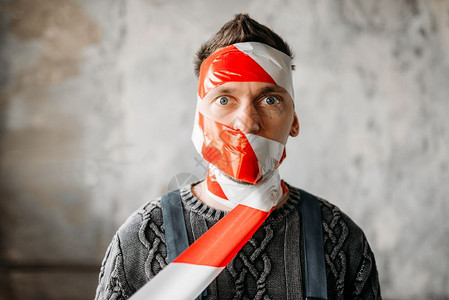 窑洞内室自闭症将他的脸裹在犯罪现场胶带里内室被遗弃的房子里疯男人