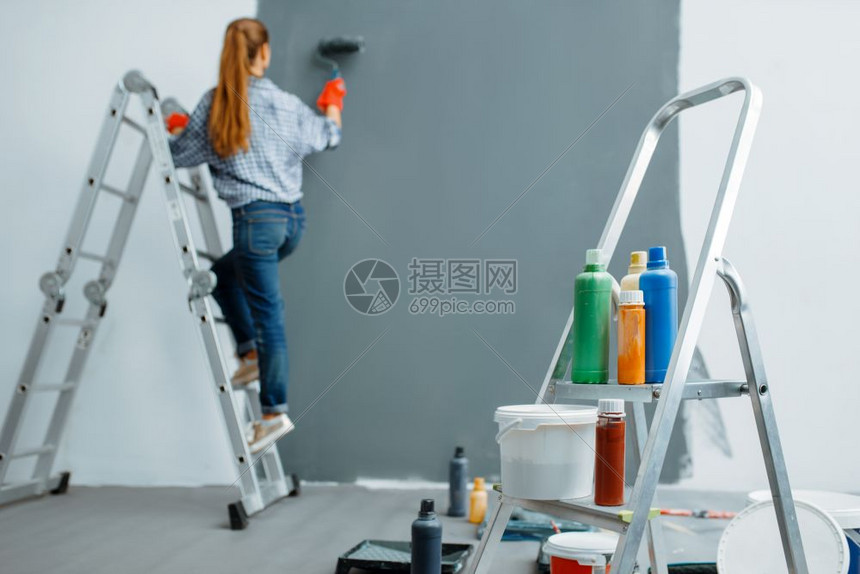 女油漆工正在粉刷
