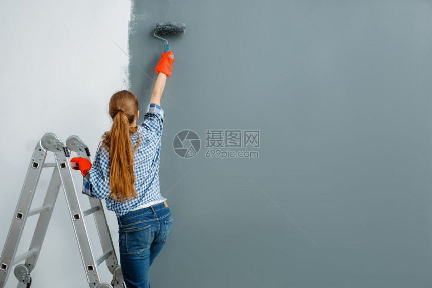 女油漆工正在粉刷